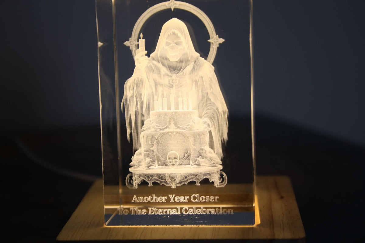 Grim Reaper with a birthday cake engraved in crystal